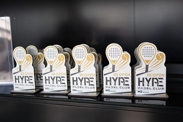 A fila de troféus brancos em forma de raquete, com o logótipo dourado do III Open.
